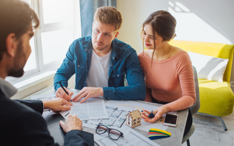Viviendas amplias Pareja firmando la compra de una vivienda con asesor inmobiliario en Alicante
